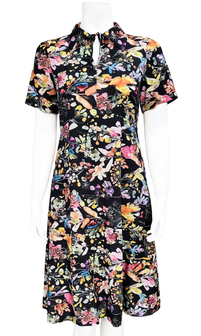 A short-sleeve collared dress with a vibrant multicolor floral print on a black background, displayed on a white mannequin against a white background.