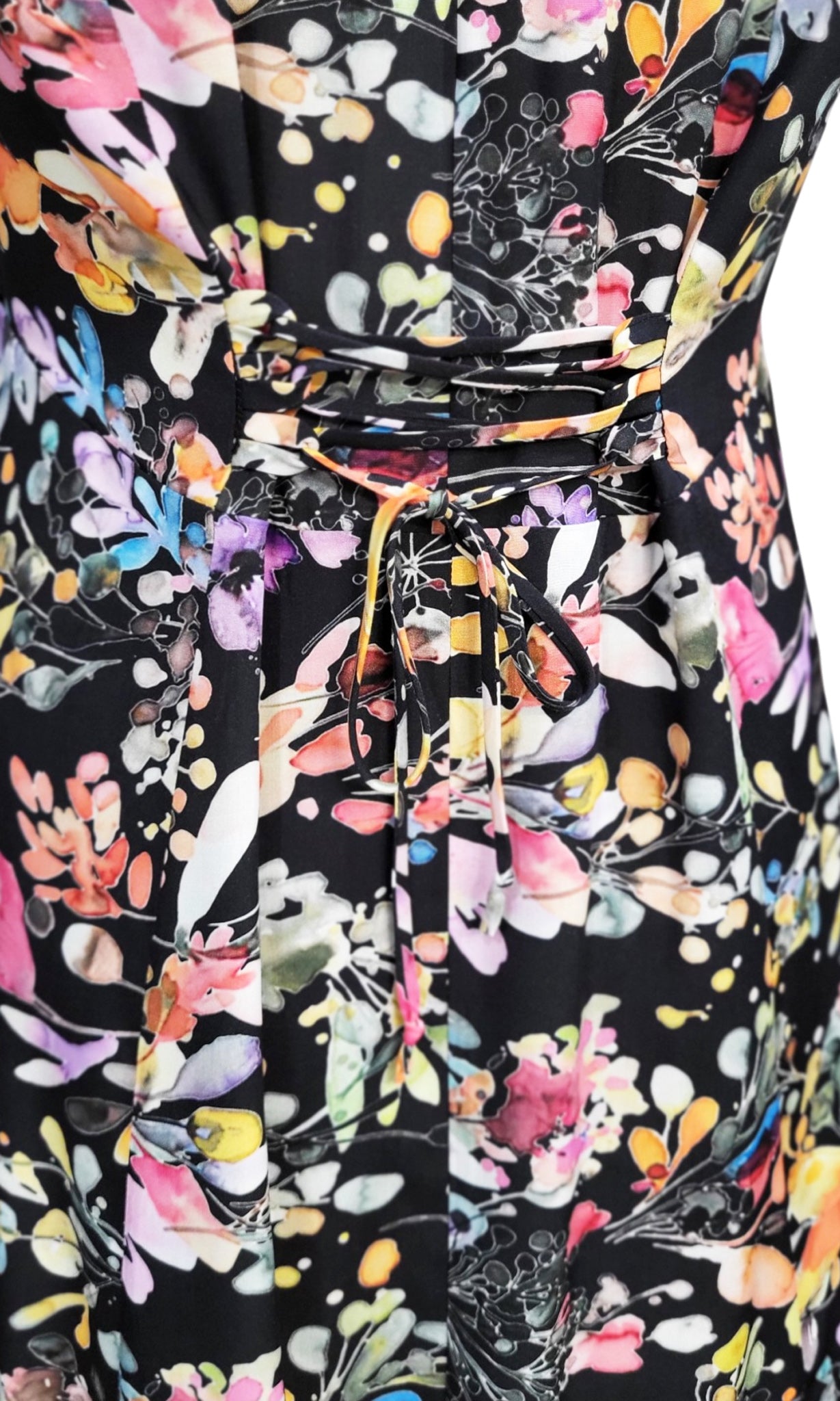 Close-up of a black dress with a colorful floral print, featuring a loose corset adjustable tie back waist.